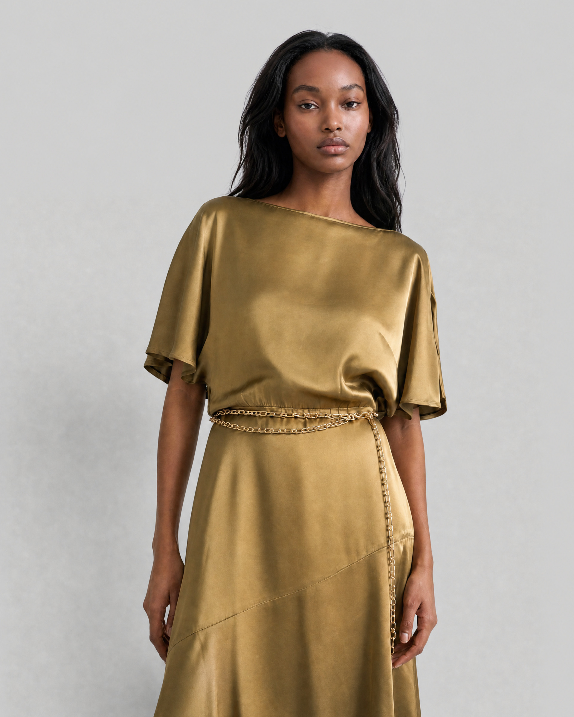 Long satin dress with an olive-colored gold chain