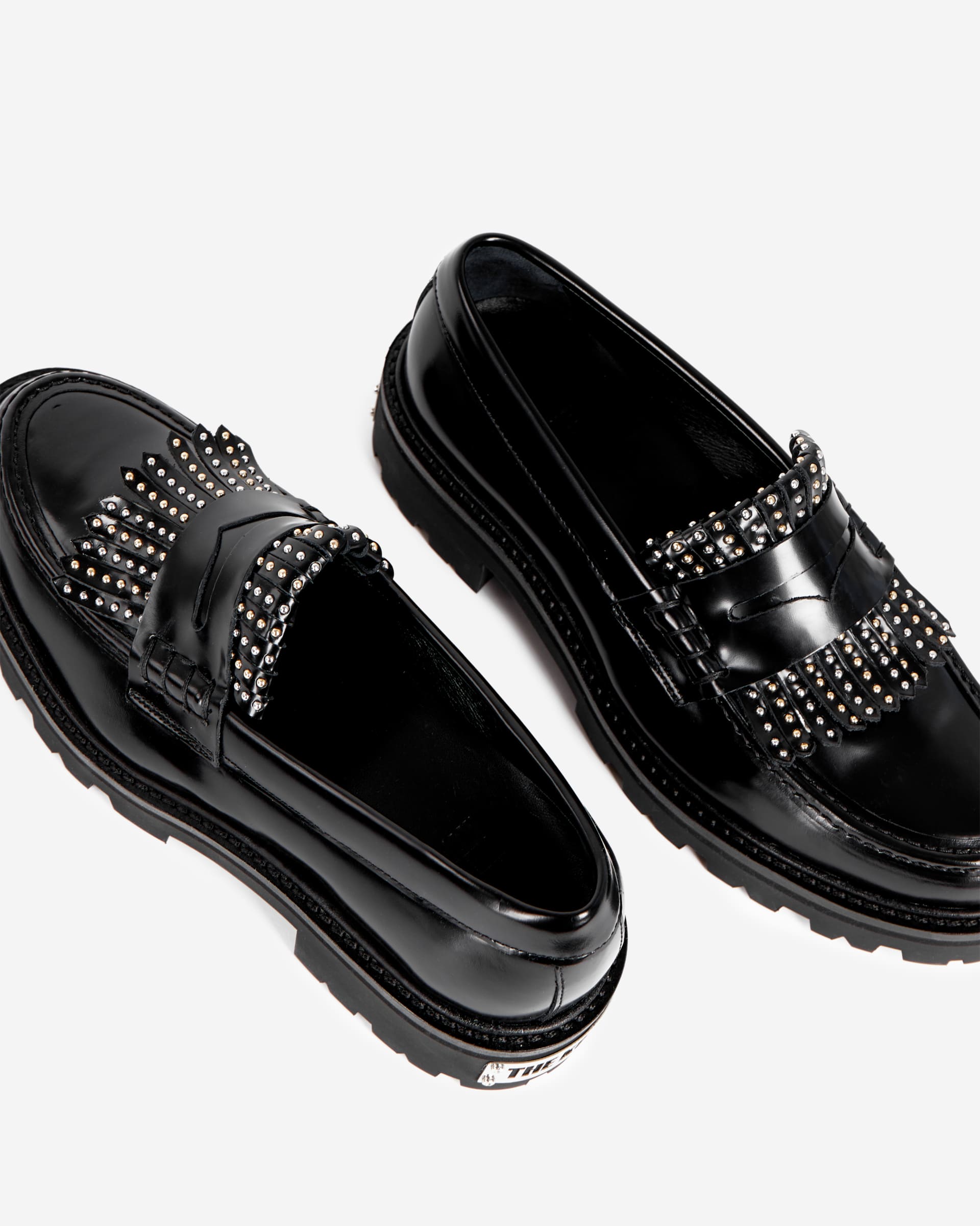 Penny loafers in black leather with fringes and studs